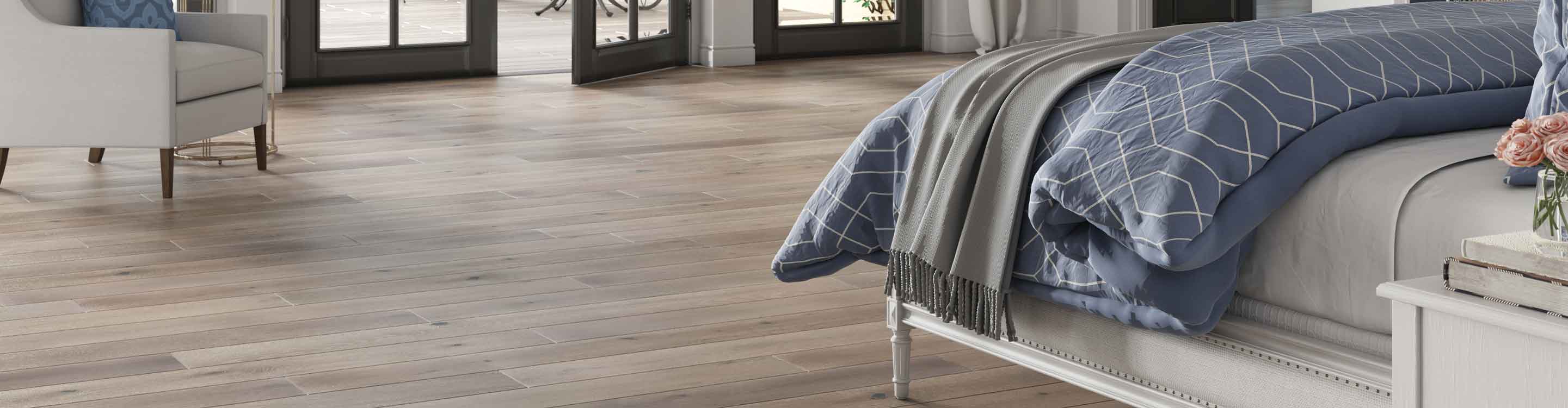 bedroom with gray hardwood floors and fireplace